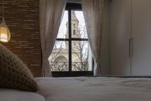 洛格罗尼奥Apto con vistas a la catedral y aire acondicionado的一间卧室设有一张床,窗户与大楼相连