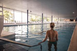 蒙特勒艾克森耶大酒店的站在游泳池的水中的女人