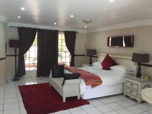 约翰内斯堡Summerview Guest Lodge的卧室配有一张白色大床和一把椅子