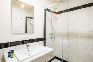塞维利亚Jardin de la Alameda Hostal Boutique的白色的浴室设有水槽和淋浴。