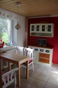 LetschinFerienhaus Loose 8的厨房配有桌椅和红色墙壁