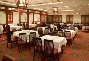 维多利亚维多利亚红狮套房酒店的餐厅内带白色桌椅的用餐室