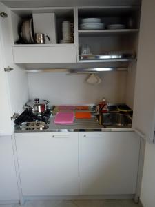 博尔索-德尔格拉帕Salvia e Timo Rooms的小厨房配有白色橱柜和炉灶。