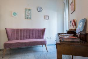 塞维利亚Jardin de la Alameda Hostal Boutique的客厅配有紫色椅子和桌子