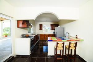 TenexcalcoMirador del Castillo的厨房配有带椅子的柜台和冰箱。