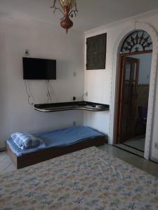 马塞约Casa da Josi - Pajuçara的一间卧室配有一张床、一台电视和一面镜子