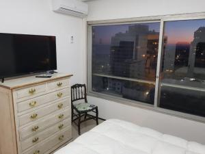 埃斯特角城APTO 913 - Piso 9 SANTOS DUMONT Excepcional vista al mar y a la ciudad的一间卧室设有梳妆台和大窗户