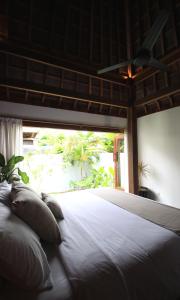 蓝梦岛阿斯马拉别墅的卧室配有一张大白色床和窗户