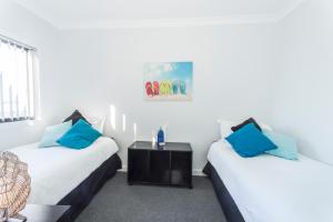布里德波特比尔科海滩和高尔夫逍遥游度假屋的两张带蓝色枕头的床