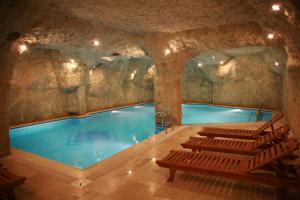 尚勒乌尔法Elruha Hotel的洞穴中的游泳池,前面设有长凳
