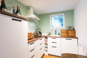 索林根Zur Burgstiege的厨房配有白色橱柜和窗户。