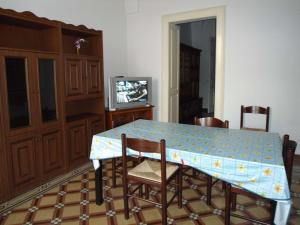 莱乌卡Casa Tipica的一间带桌椅和电视的用餐室
