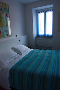 韦尔纳扎詹尼弗兰西酒店的卧室里带条纹毯子的床