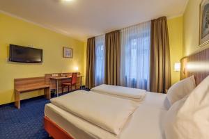 科隆温莎酒店的酒店客房配有两张床和一张书桌