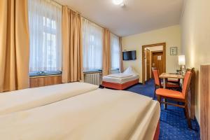 科隆温莎酒店的酒店客房设有一张大床和一张书桌。
