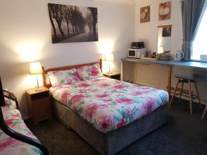MarthallChelford Guesthouse的一间卧室配有一张床和一张书桌
