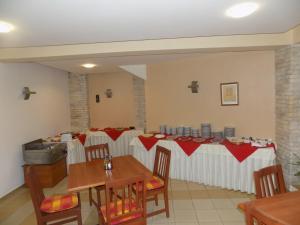 克兰内沃塞雷纳酒店的用餐室配有红色和白色桌布的桌子