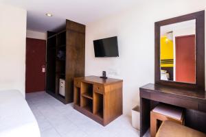 芭堤雅市中心18 Coins Budget Hotel的一间设有镜子、梳妆台和电视的房间
