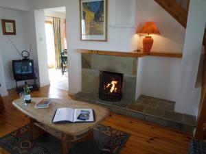 Achill SoundAchill Sound Holiday Village的客厅设有壁炉和桌子