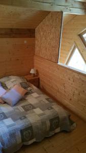 奥雷勒La cabane du pommier的小木屋内一间卧室,配有一张床