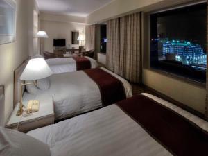 四日市Miyako Hotel Yokkaichi的酒店客房设有两张床和一台平面电视。