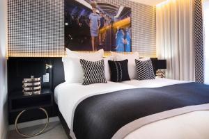 巴黎Hôtel Dress Code的一间卧室配有一张大床,提供黑白枕头