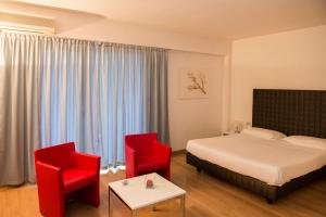 克雷马公园宅邸酒店的酒店客房,配有一张床和两张红色椅子