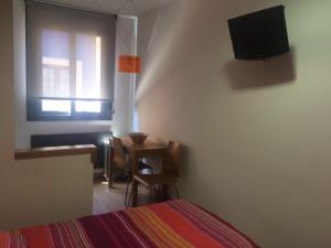 康达Alojamientos Maramar的一间卧室配有一张床、一张桌子和一台电视