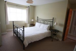 邓莫尔东Glen Ard Holiday Home No 1的一间卧室设有一张黑色的床和一个窗户。