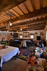 ŞurdeştiIz de Maramures Rural Hotel的一间带桌椅的客厅和一间餐厅