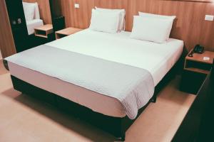 皮拉西卡巴欧西塔诺阿帕特酒店的卧室配有一张带白色床单和枕头的大床。