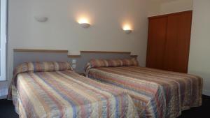 巴黎德沃奇酒店的酒店客房,设有两张床和两盏灯