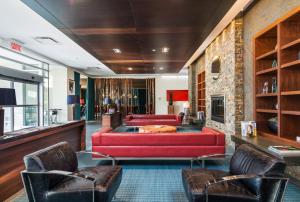 多瓦尔蒙特利尔机场诺富特酒店的客厅配有红色的沙发和椅子