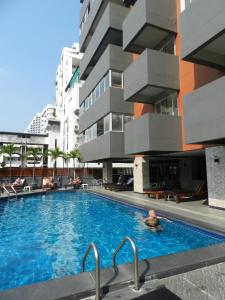 曼谷纳南泰套房酒店的建筑物旁游泳池里的男人