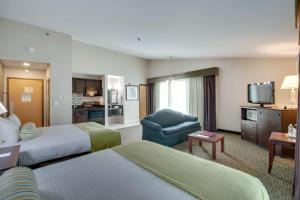 汉普顿Best Western Plus, The Inn at Hampton的酒店客房,配有两张床和椅子