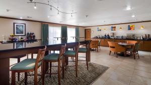 舍尔茨贝斯特韦斯特PLUS中庭酒店的餐厅设有酒吧,配有椅子和桌子
