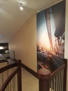 米兹多洛杰Apartament Baltic Marea的一间设有楼梯的房间,墙上挂着一幅船画
