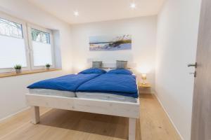 乌埃克尔明德Ferienwohnung Küstenurlaub Ueckermünde的白色卧室配有蓝色枕头的床