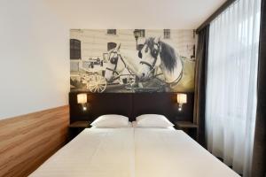 维也纳露西亚酒店的一间卧室,配有一张带马匹照片的床