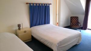 阿拉东美丽里瓦奇酒店的一间卧室配有两张床和蓝色窗帘