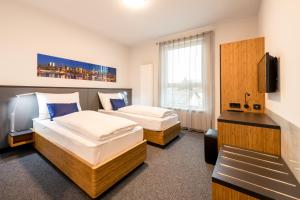格里斯基兴Motel Grieskirchen superior的酒店客房设有两张床和电视。
