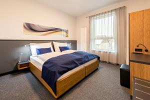 格里斯基兴Motel Grieskirchen superior的一间卧室配有一张带蓝色床单的床和一扇窗户。