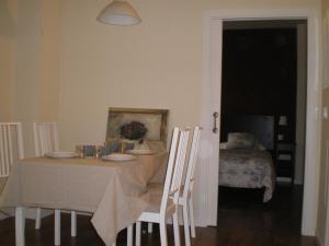 塞维利亚塞维利亚古城墙公寓式酒店的用餐室配有桌椅、桌子和床