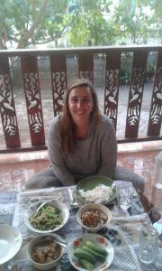 Ban BoGarden Home, Chanthaburi的坐在餐桌上吃盘子的女人