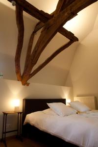 马塞克安格克劳斯特住宿加早餐旅馆的一间卧室设有一张带木梁的大床