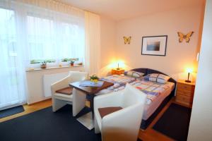 青斯特Feriendomizil am Hafen的卧室配有一张床和一张桌子及椅子