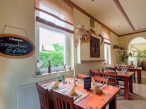 吕本瑙卡托非加斯特豪斯尼德宾希酒店的餐厅设有一张大型木桌和椅子