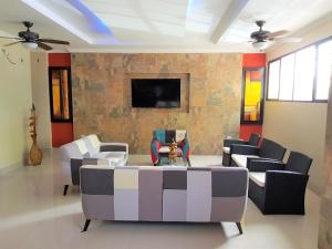 瓜亚基尔Hotel Apart Guayaquil Aeropuerto的客厅配有沙发、椅子和电视