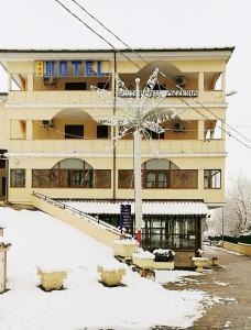 卡斯特罗维拉里Hotel La Falconara的大楼前有雪的酒店