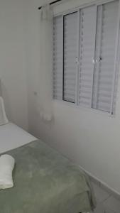 朱奎Pousada do Pascoal的一间白色卧室,配有床和2个窗户